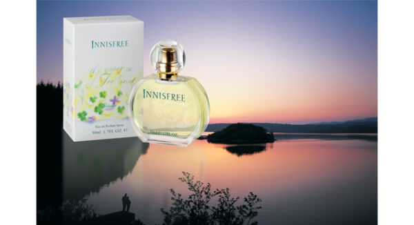 A bottle of perfume sitting on top of a body of water.