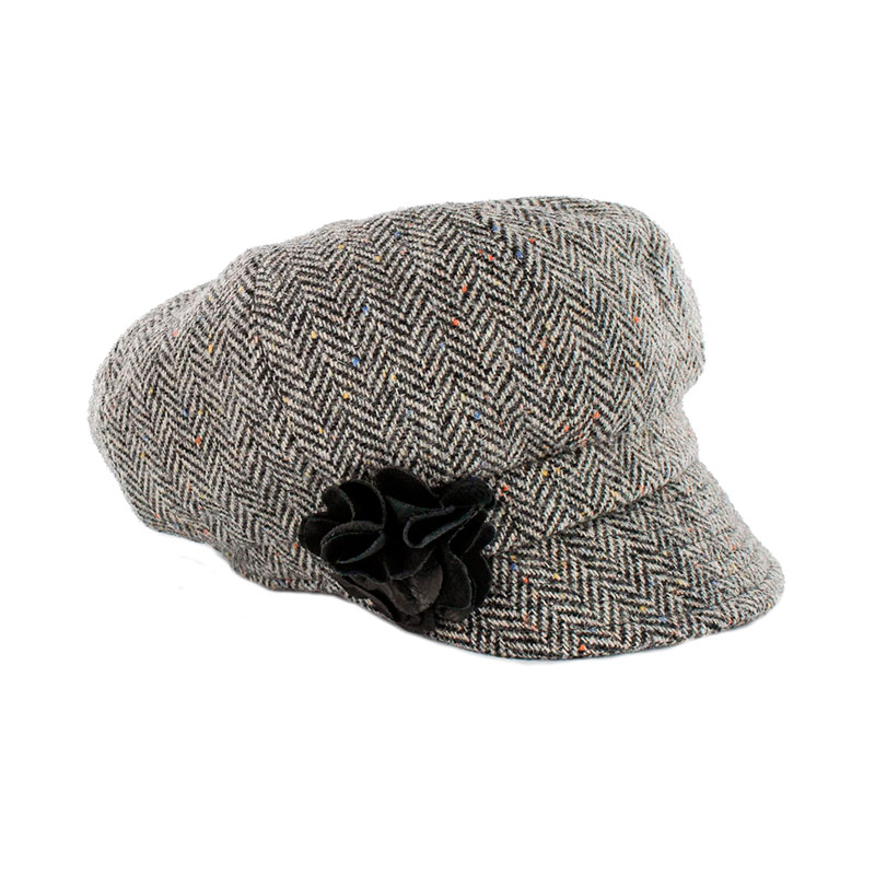 A gray hat with black flower on top of it.