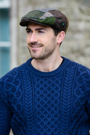 A man in a sweater and hat is smiling.