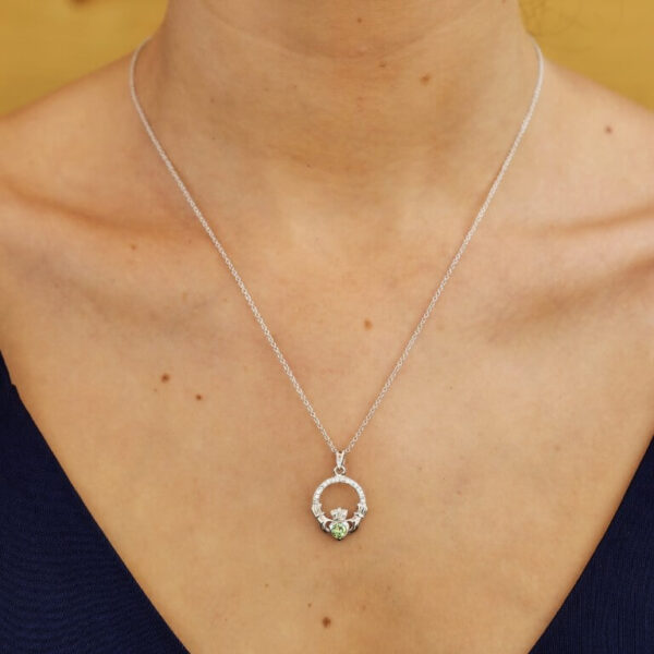 A woman wearing a necklace with two small charms.