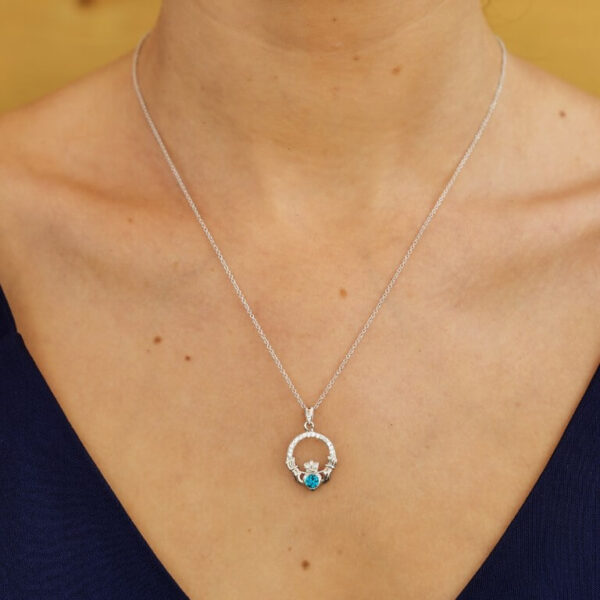 A woman wearing a necklace with two stones on it.