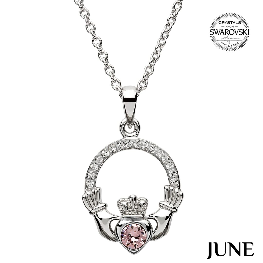 A claddagh necklace with pink heart shaped stone.