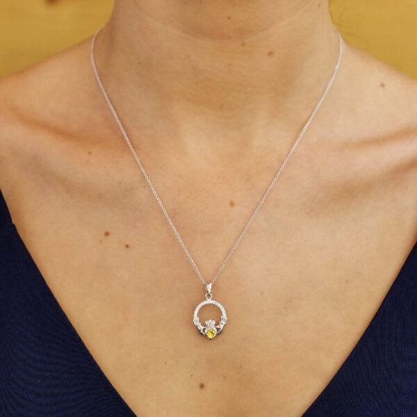 A woman wearing a necklace with a flower design.