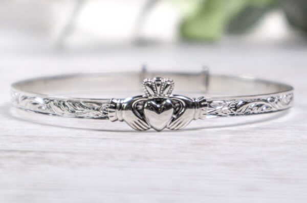 A claddagh bracelet is shown on top of a table.