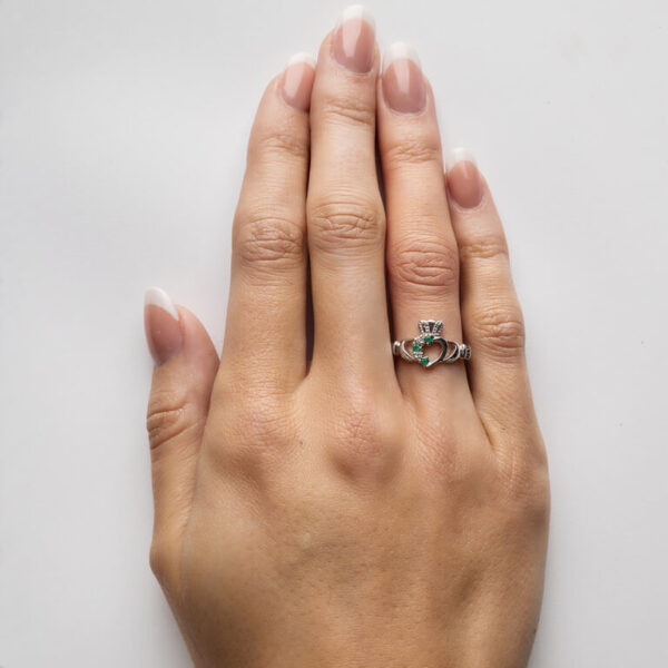 A woman 's hand with two rings on it