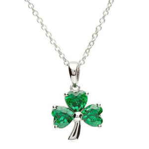A silver necklace with a green shamrock on it.