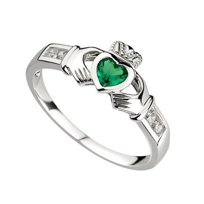 A claddagh ring with emerald heart and diamond accents.