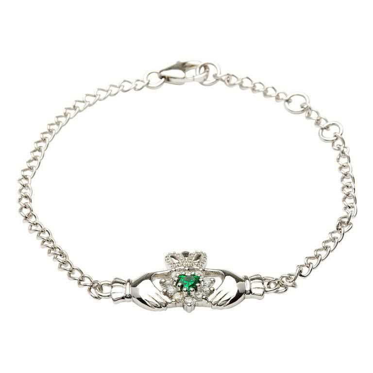 A silver bracelet with a claddagh design and green stone.