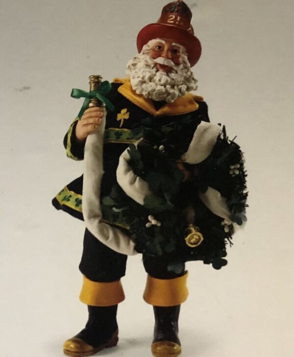 A toy santa claus holding a wreath and a sword.