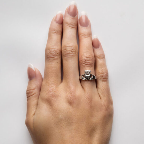 A woman 's hand with a claddagh ring on it.