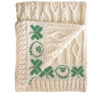A white blanket with green designs on it.