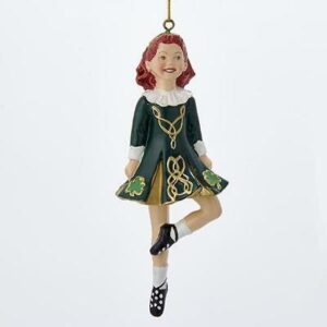 A girl in green dress hanging ornament.