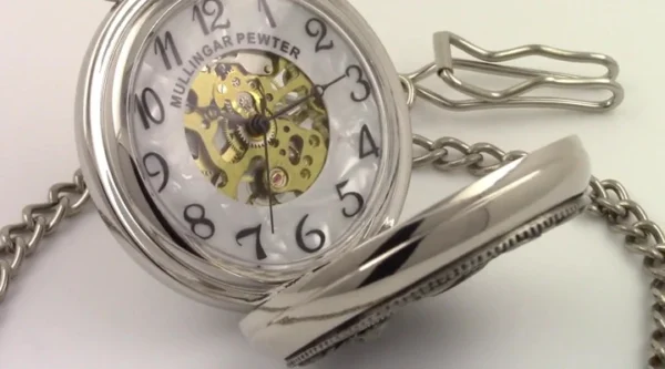 A pocket watch with a chain and a pair of scissors.