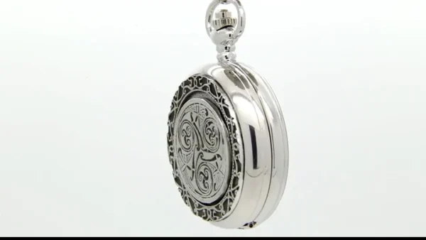 A silver pocket watch with a decorative design.