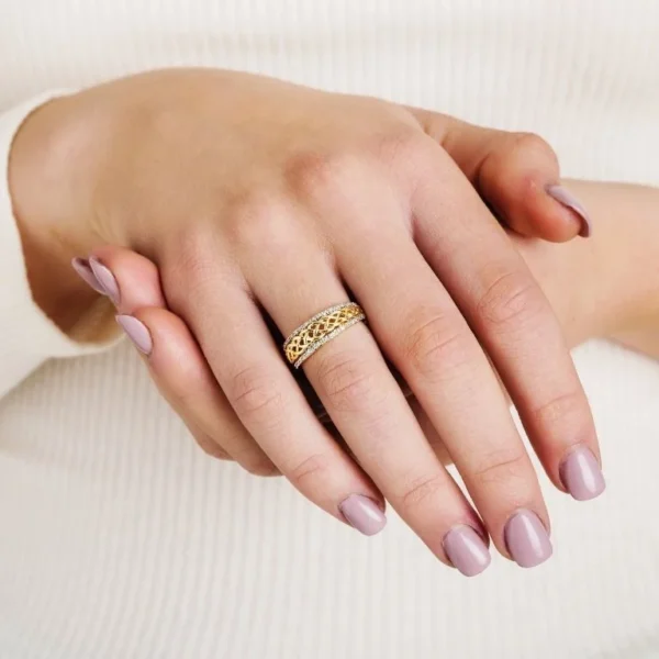A woman 's hands with a gold ring on top of them.