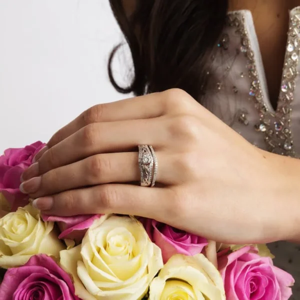 A woman is holding her wedding ring on the finger of her hand.