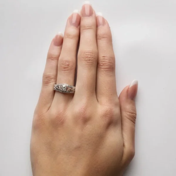 A woman 's hand with a wedding ring on it.