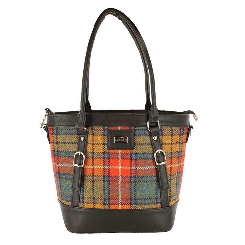 A plaid bag with black leather handles and straps.