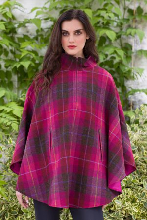 A woman in a plaid poncho standing outside.