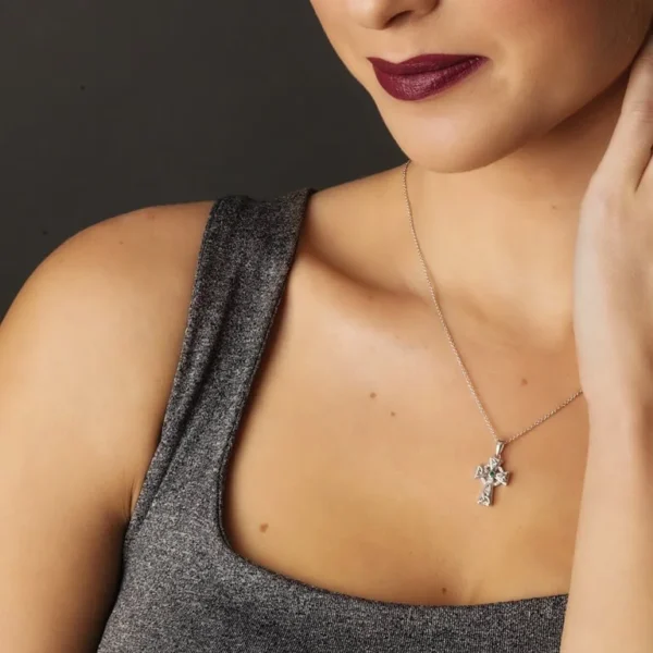 A woman wearing a necklace with a cross on it.