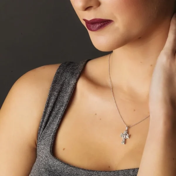 A woman wearing a necklace with a cross on it.