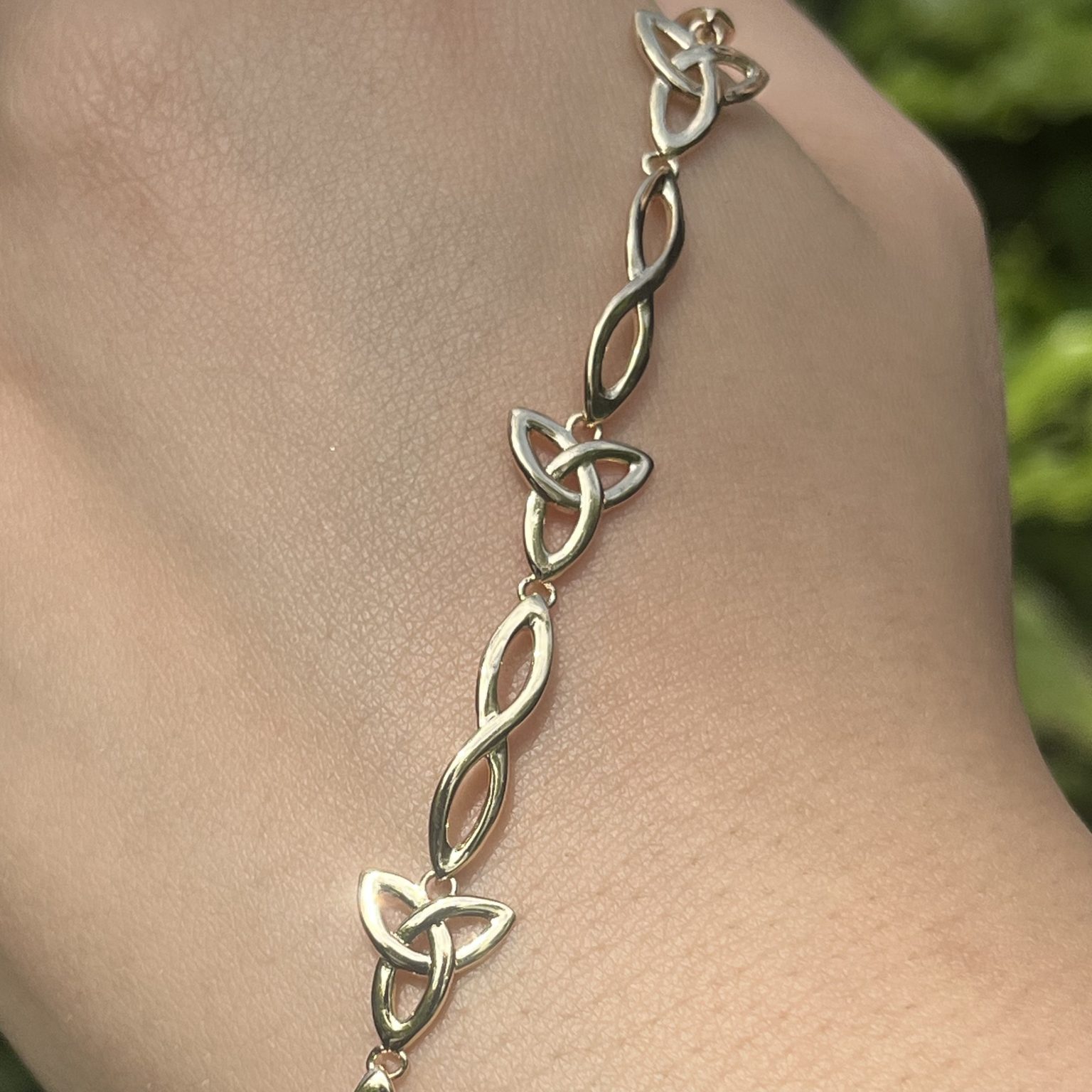 Gold Celtic knot bracelet on wrist.