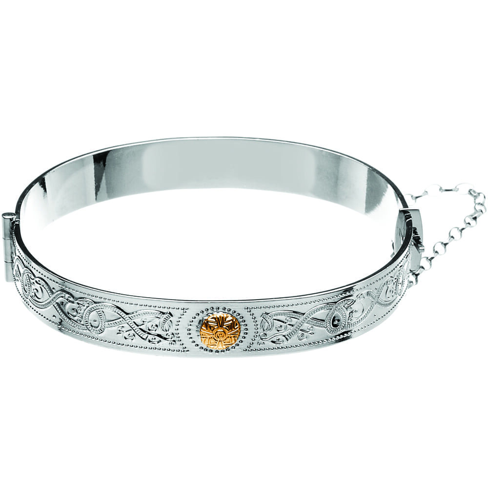 A silver bangle with an orange stone on it.