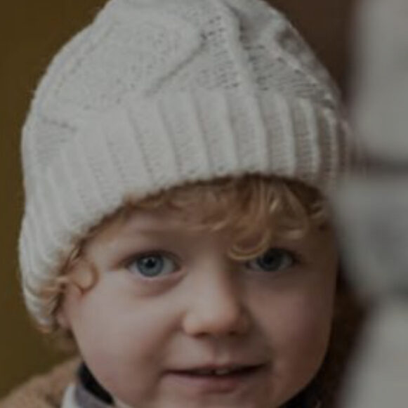 A child wearing a white hat and jacket.