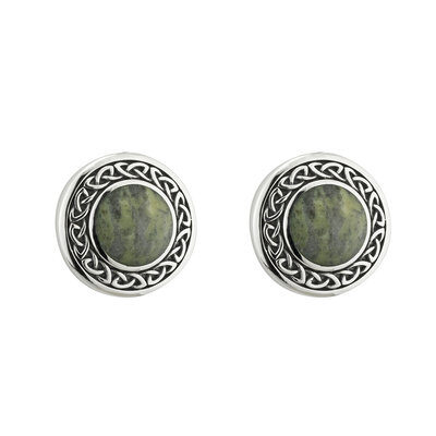 A pair of earrings with green stones and silver frame.