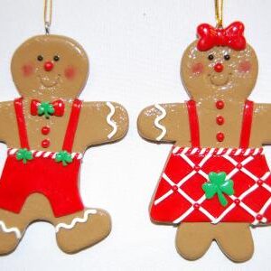 Two gingerbread ornaments are hanging on a wall.