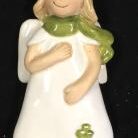 A ceramic angel with green scarf on it's chest.