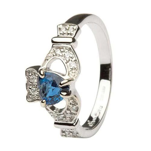 A claddagh ring with blue stone on it's side.