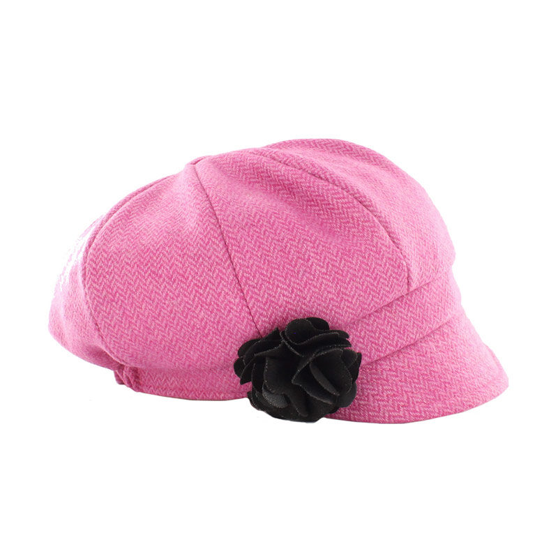 A pink hat with a black flower on it.