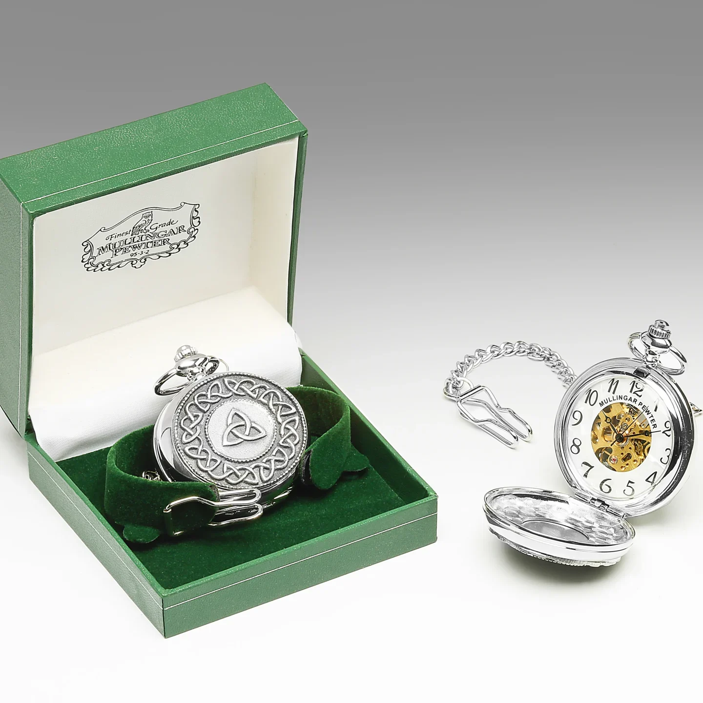 A silver pocket watch sitting in its box next to another one.