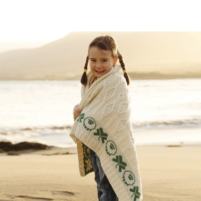 A little girl wrapped in a blanket on the beach